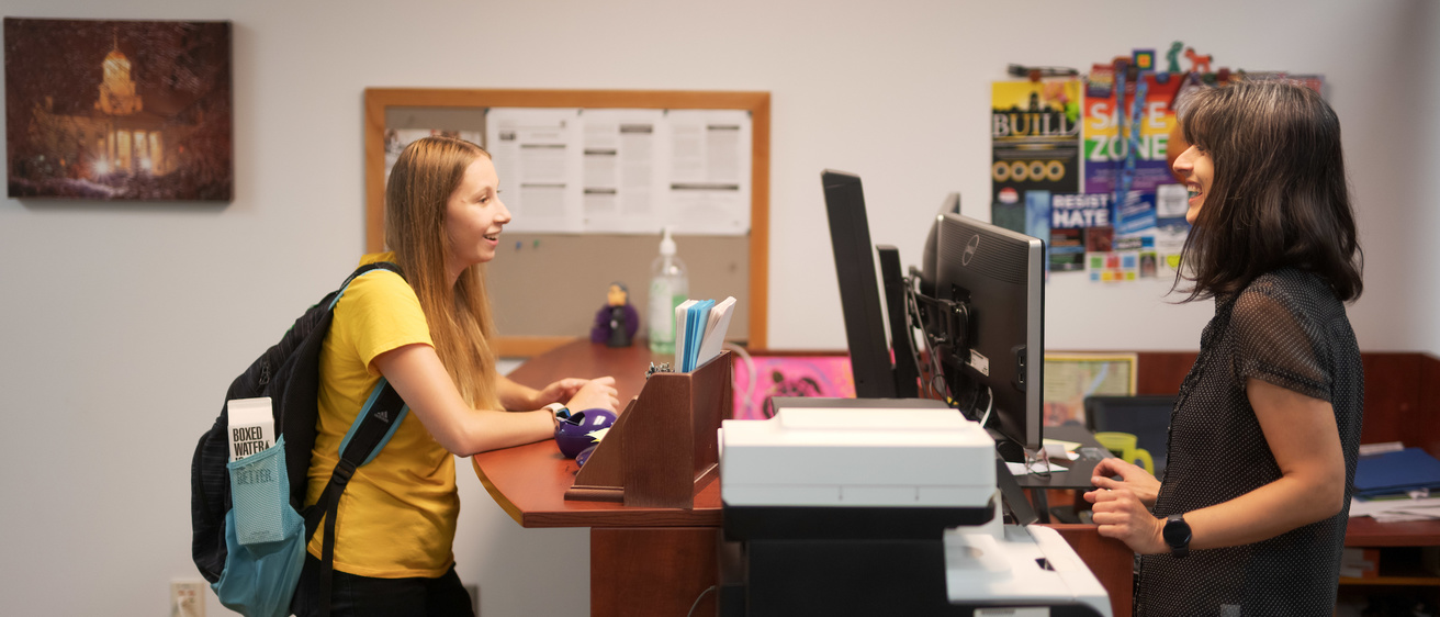 A student being welcomed at the SLS front desk